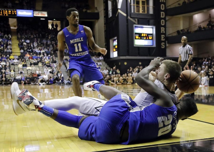 Middle Tennessee guard Giddy Potts (20) dives for the ball with Vanderbilt guard Riley LaChance in the second half of an NCAA college basketball game Wednesday, Dec. 6, 2017, in Nashville, Tenn. Middle Tennessee guard Edward Simpson (11) watches. Middle Tennessee won 66-63. (AP Photo/Mark Humphrey)