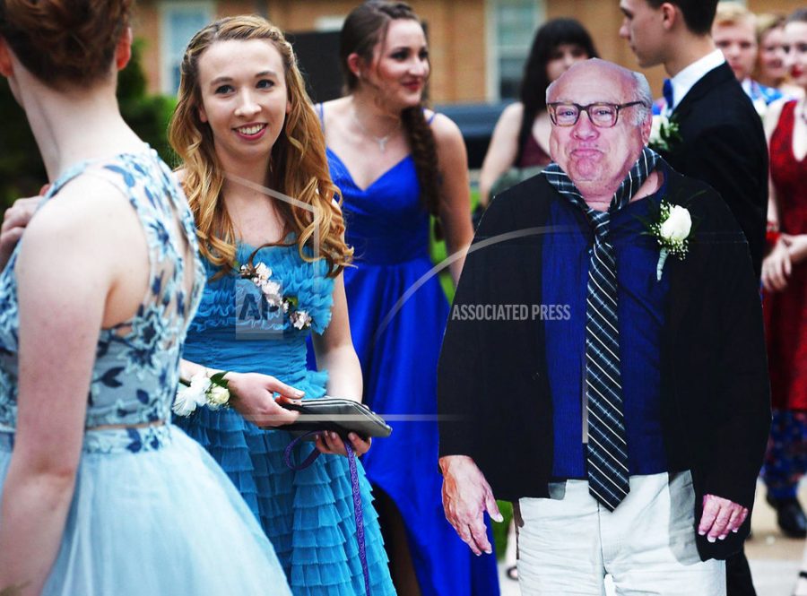Allison Closs arrives for the Carlisle High School senior prom at Letort View Community Center at Carlisle Barracks in Carlise, Pa., on Friday, May 11, 2018, with a cutout of actor Danny DeVito. Closs and her famous two-dimensional date joined other Carlisle High School seniors Friday for prom. Closs purchased the cutout of DeVito online along with a scooter she used to move the figure with.   (Michael Bupp /The Sentinel via AP)