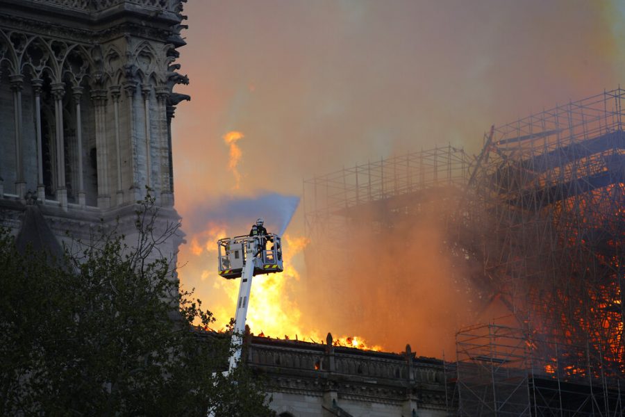 A firefighter uses a hose as Notre Dame cathedral burns in Paris, Monday, April 15, 2019. A catastrophic fire engulfed the upper reaches of Paris soaring Notre Dame Cathedral as it was undergoing renovations Monday, threatening one of the greatest architectural treasures of the Western world as tourists and Parisians looked on aghast from the streets below. (AP Photo/Francois Mori)