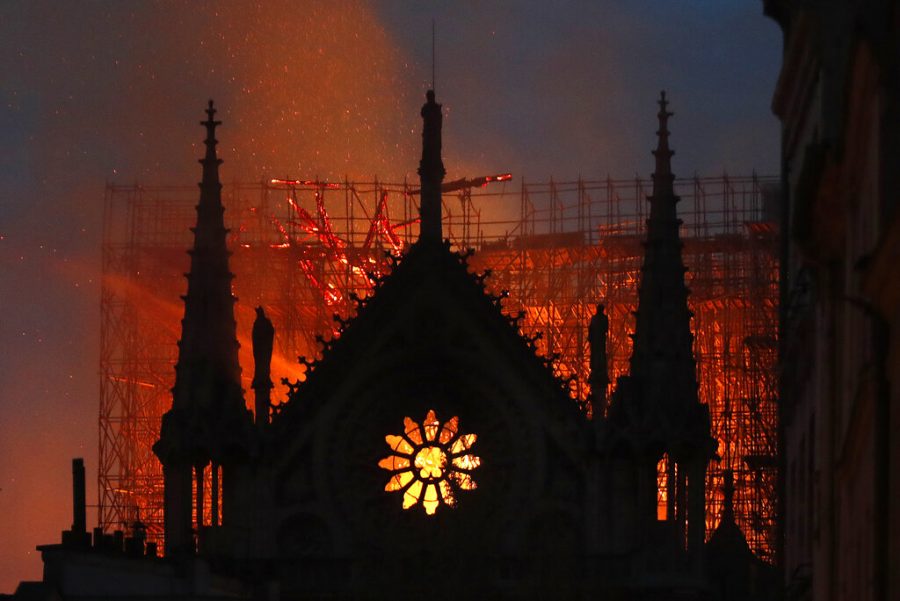 Flames and smoke rise from Notre Dame cathedral as it burns in Paris, Monday, April 15, 2019. Massive plumes of yellow brown smoke is filling the air above Notre Dame Cathedral and ash is falling on tourists and others around the island that marks the center of Paris. (AP Photo/Thibault Camus)