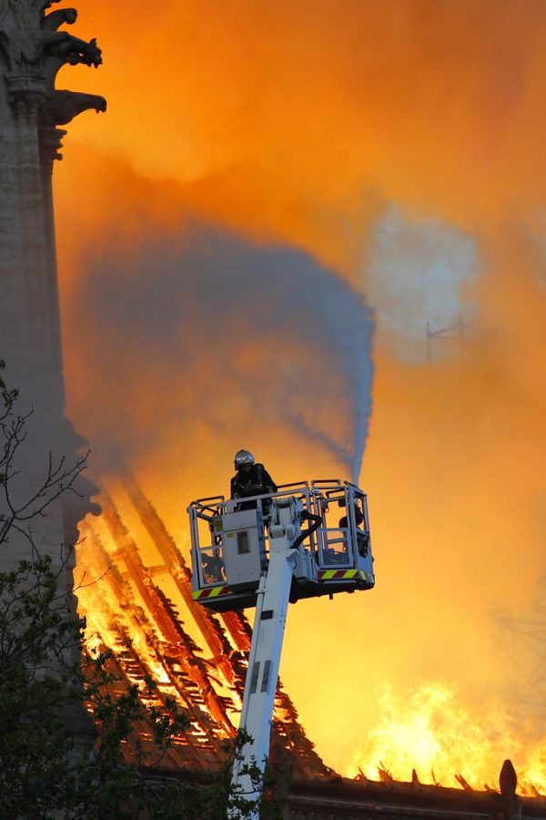 A fire fighter uses a hose as Notre Dame cathedral is burning in Paris, Monday, April 15, 2019. A catastrophic fire engulfed the upper reaches of Paris soaring Notre Dame Cathedral as it was undergoing renovations Monday, threatening one of the greatest architectural treasures of the Western world as tourists and Parisians looked on aghast from the streets below. (AP Photo/Francois Mori)