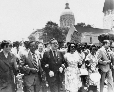 FILE - In this May 1970 file photo, Leonard Woodcock, newly elected president of the United Auto Workers Union, in glasses and dark suit, locks arms with Coretta Scott King, wife of slain the Rev. Dr. Martin Luther King Jr., and the Rev. Joseph E. Lowery as they lead several thousand marchers past the state Capitol in Atlanta in a protest march against war, violence and racial repression. Lowery, a veteran civil rights leader who helped the Rev. Dr. Martin Luther King Jr. found the Southern Christian Leadership Conference and fought against racial discrimination, died Friday, March 27, 2020, a family statement said. He was 98. (AP Photo, File)