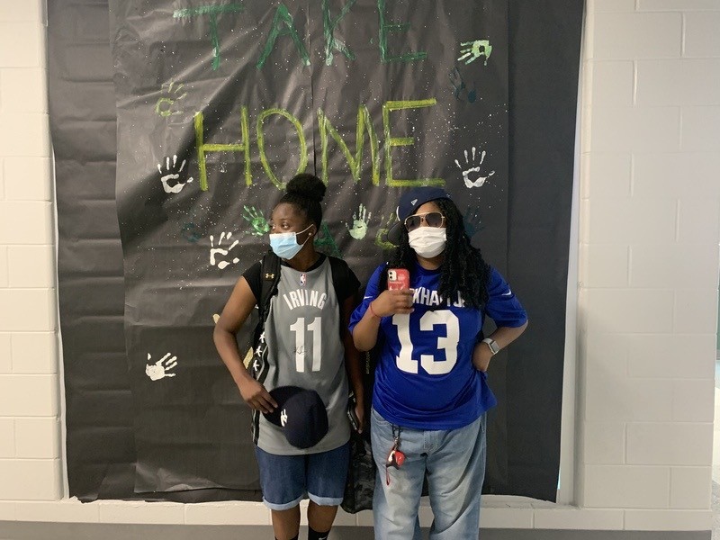 Ariana and Khaniya pose in front of a poster on September 30th, 2021 for spirit week.