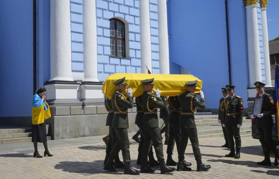 Soldiers carry a coffin with remains of a volunteer soldier Oleksandr Makhov, a well-known Ukrainian journalist, killed by the Russian troops, at St Michael cathedral in Kyiv, Ukraine, Monday, May 9, 2022. The coffin is followed by Makhovs widow.
