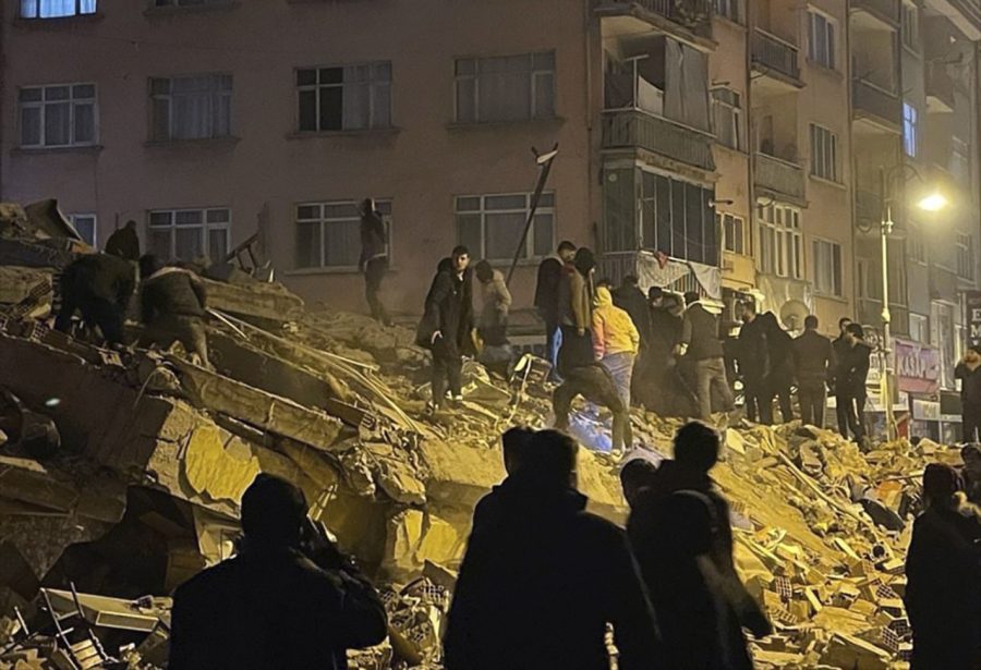 People try to reach trapped residents in a collapsed building in Pazarcik, in Kahramanmaras province, southern Turkey, early Monday, Feb. 6, 2023. A powerful earthquake has caused significant damage in southeast Turkey and Syria and many casualties are feared. Damage was reported across several Turkish provinces, and rescue teams were being sent from around the country. (Depo Photos via AP)