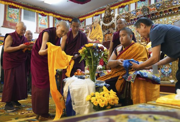 Monks bow and present “khata” to teenage Buddhist lama, Jalue Dorje, at his 18th birthday and enthronement ceremony in Isanti, Minn., on Saturday, Nov. 9, 2024. )